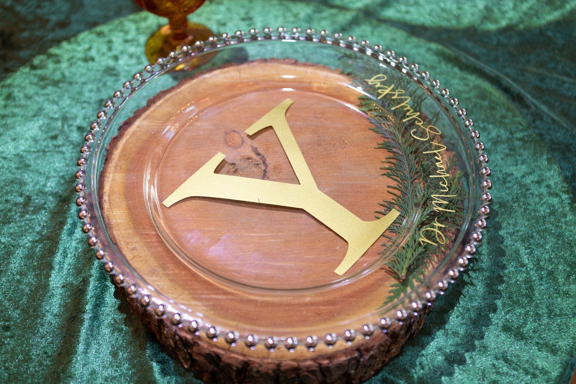 Gold letter Y on a round wooden base with green fabric background