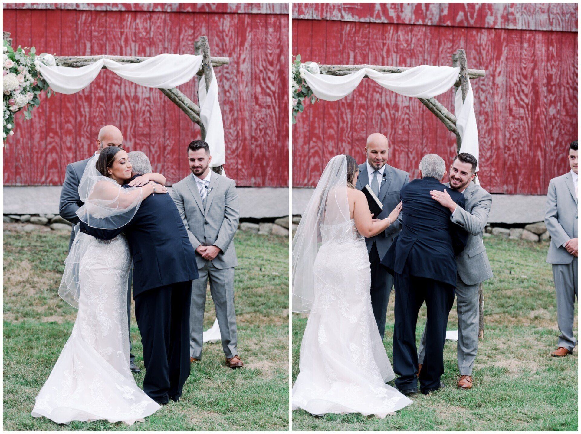 Wedding group hug outdoors near a red barn, with bride in white dress and guests embracing.