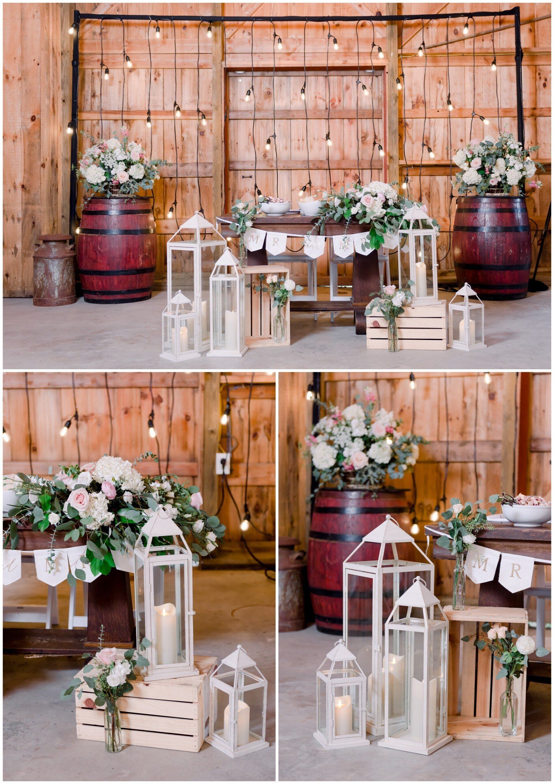 Rustic wedding display with white lanterns, flowers, and barrels against a wooden backdrop
