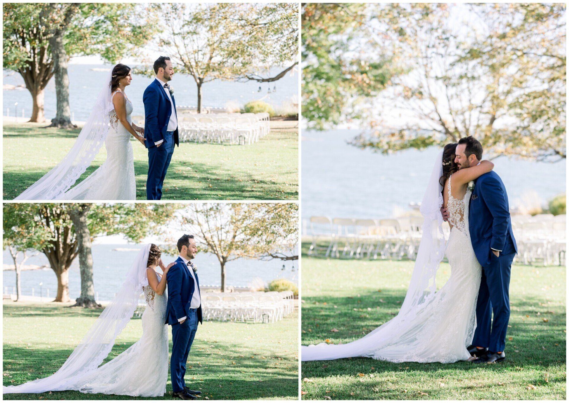 Bride and groom in blue suit sharing a kiss by the water, with a long white veil and green trees behind them
