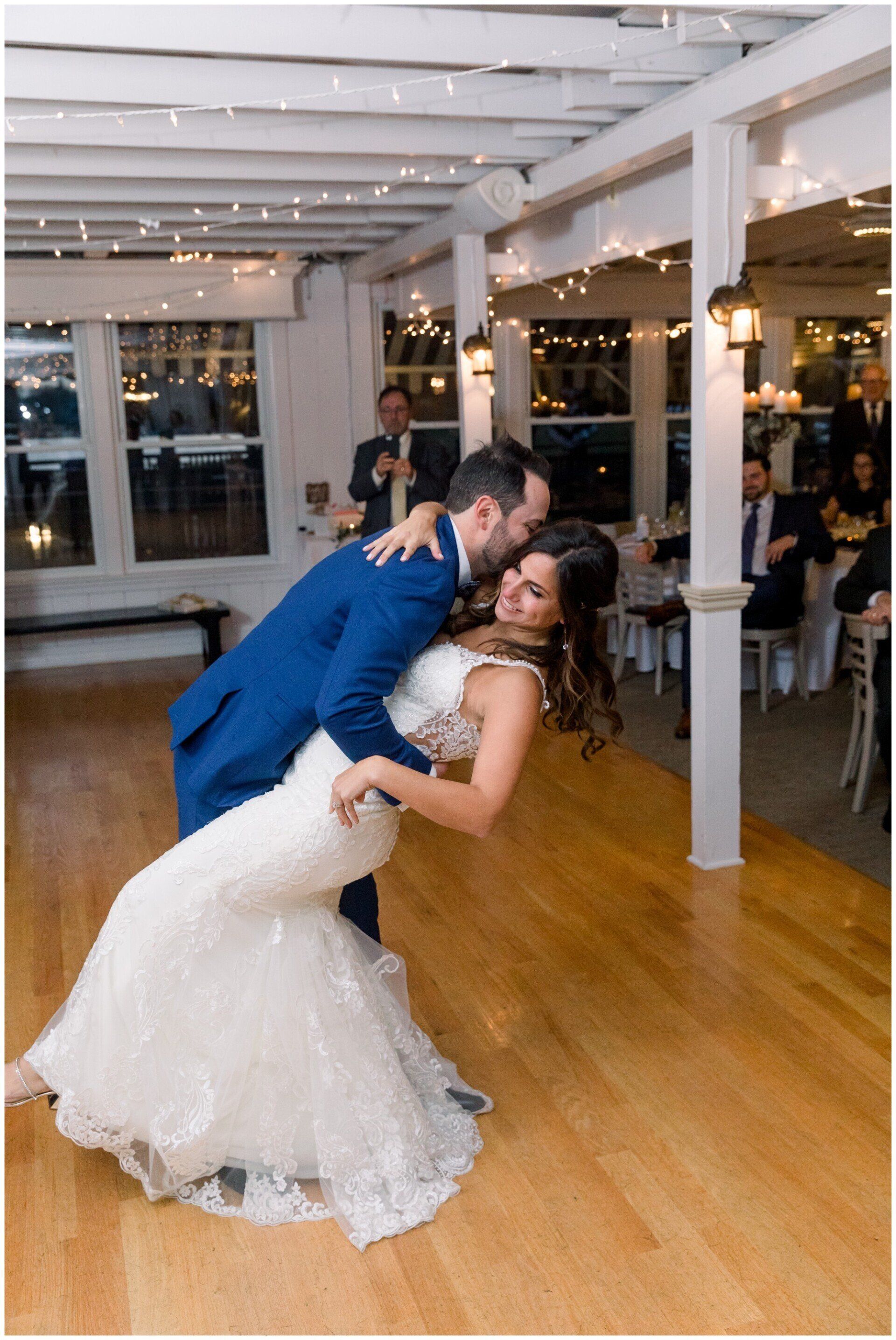 Bride dipping groom in a kiss on a dance floor at a wedding reception