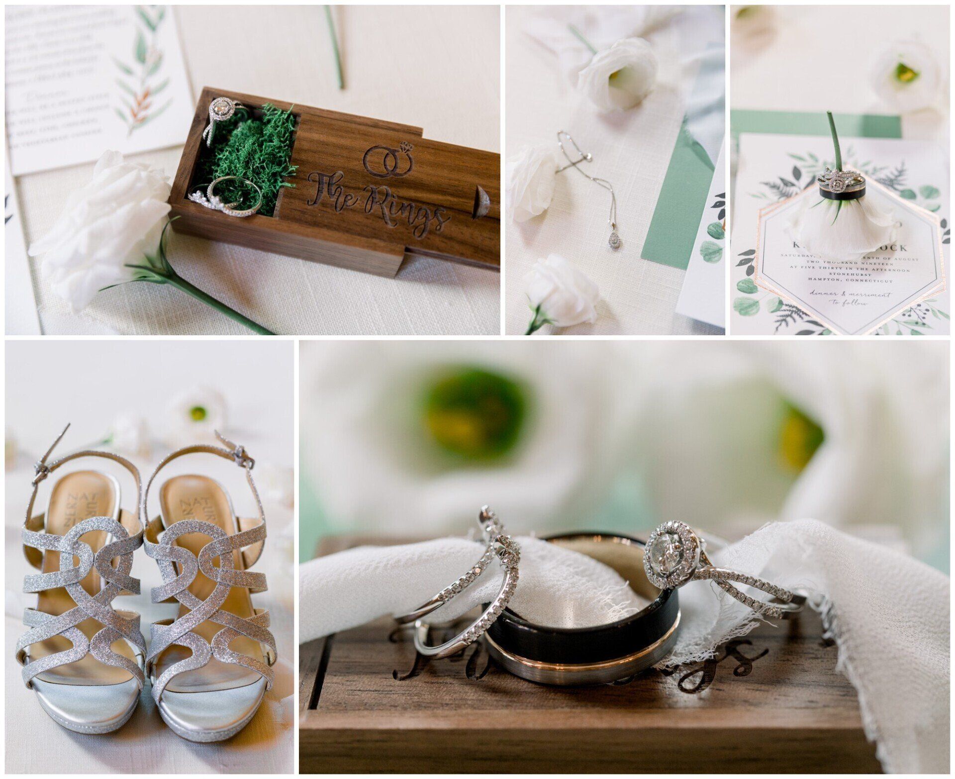 Wedding stationery and rings arranged with white flowers, green accents, and silver shoes on a wooden surface
