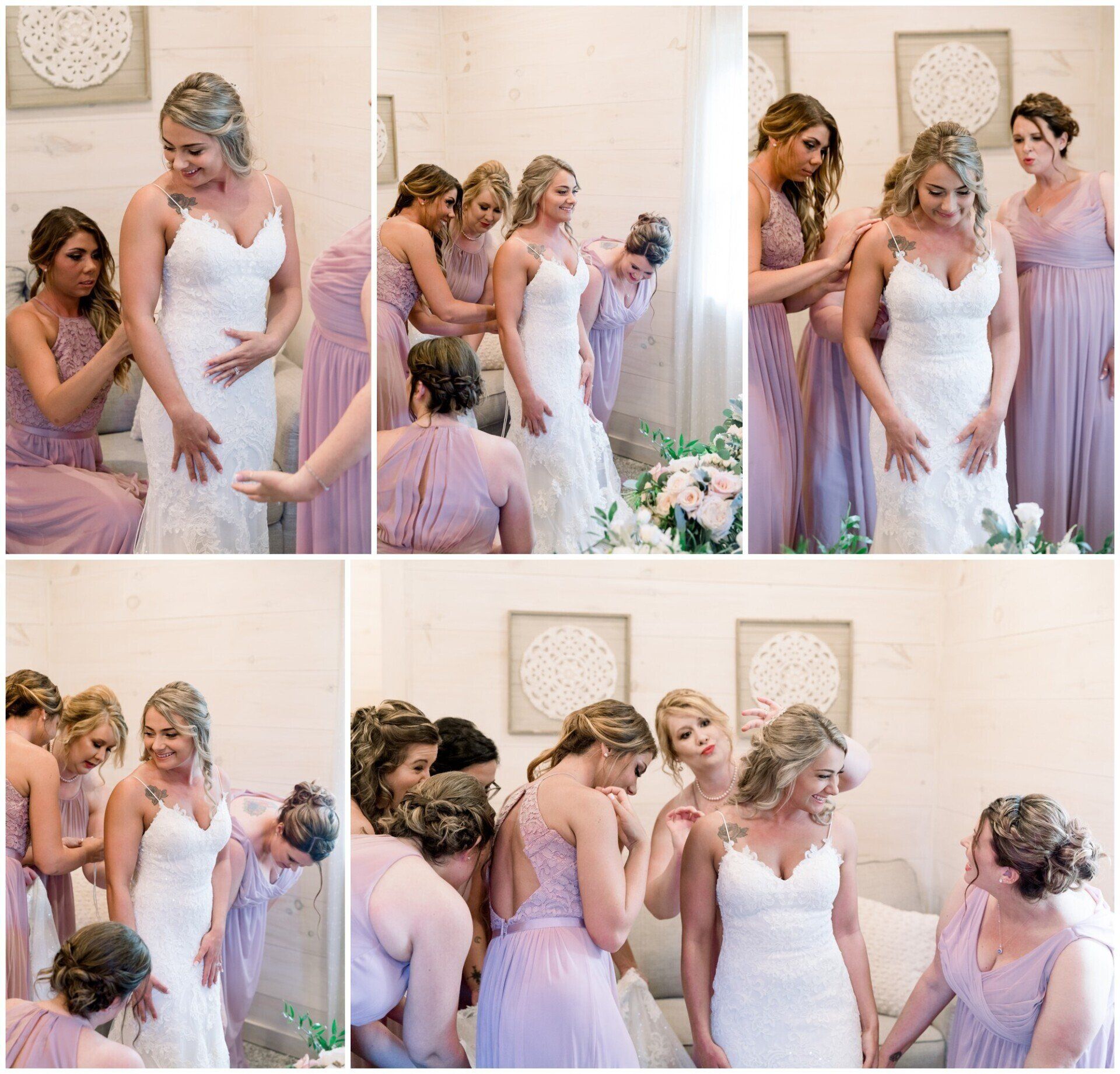 Bridesmaids help a bride adjust her white wedding dress in a soft pink room.