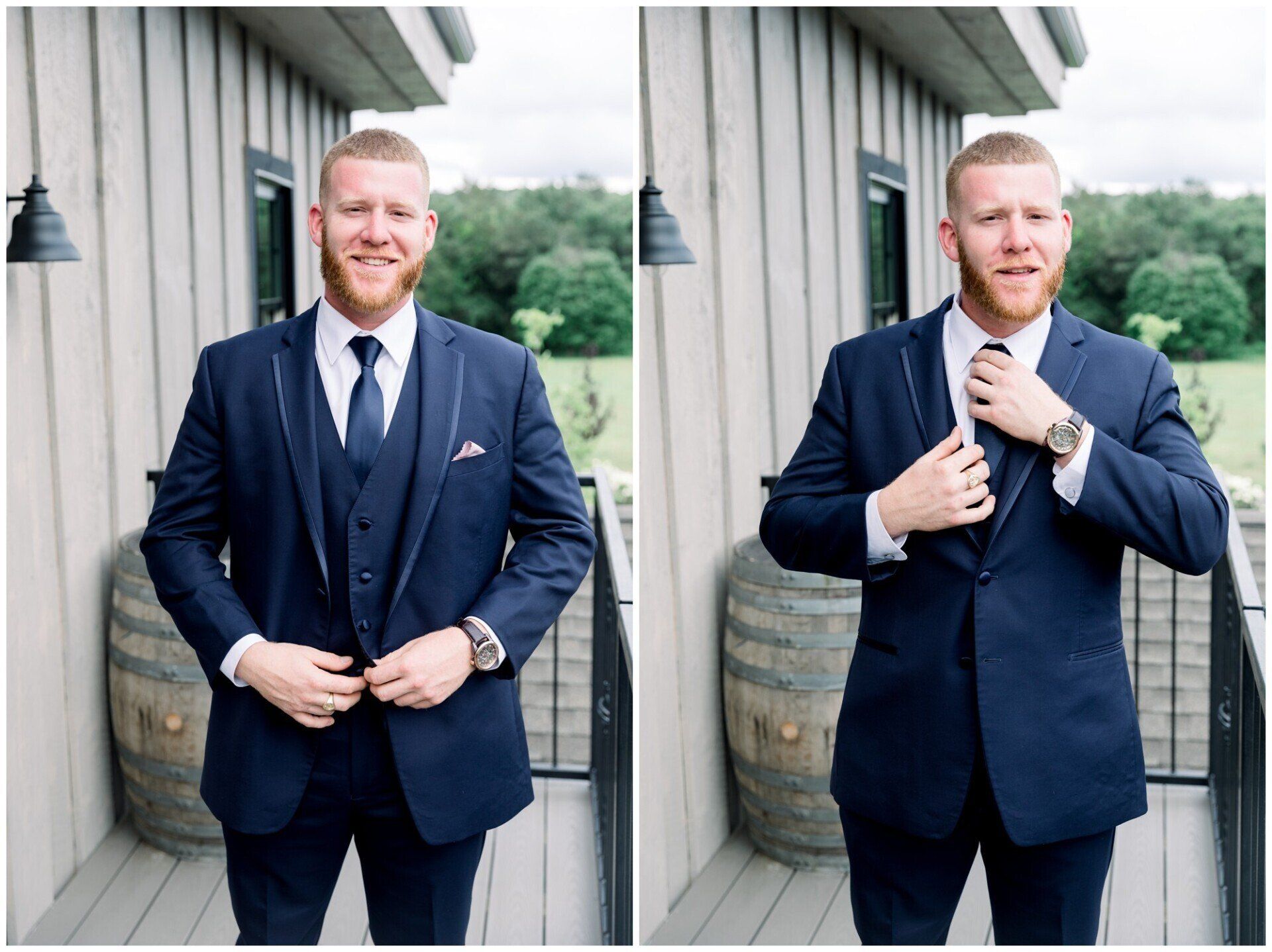 Man adjusting navy suit jacket beside a wooden building, standing on a porch with a barrel in the background