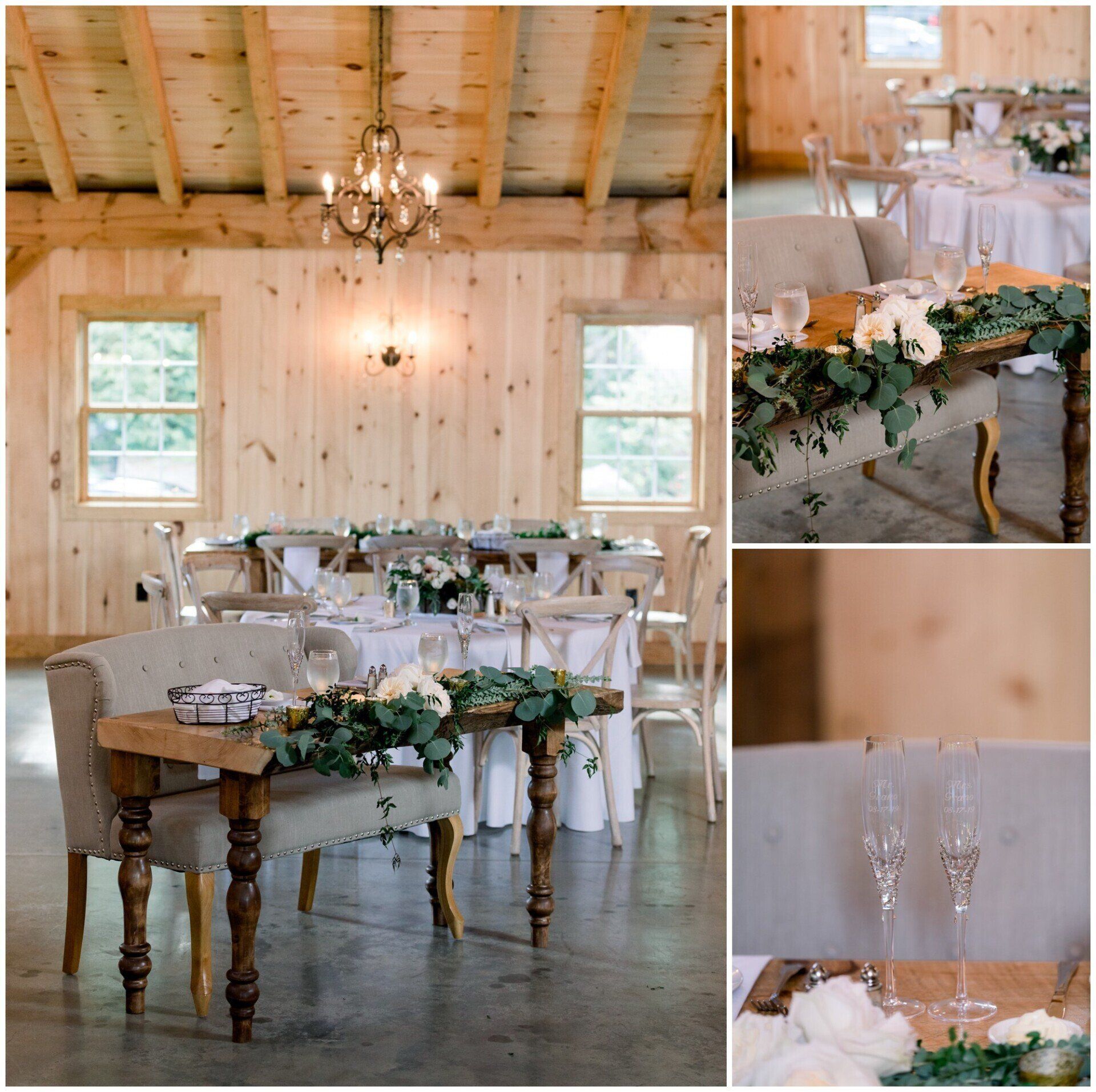 Rustic white barn reception room with tables, greenery, chandeliers, and a decorated wooden head table