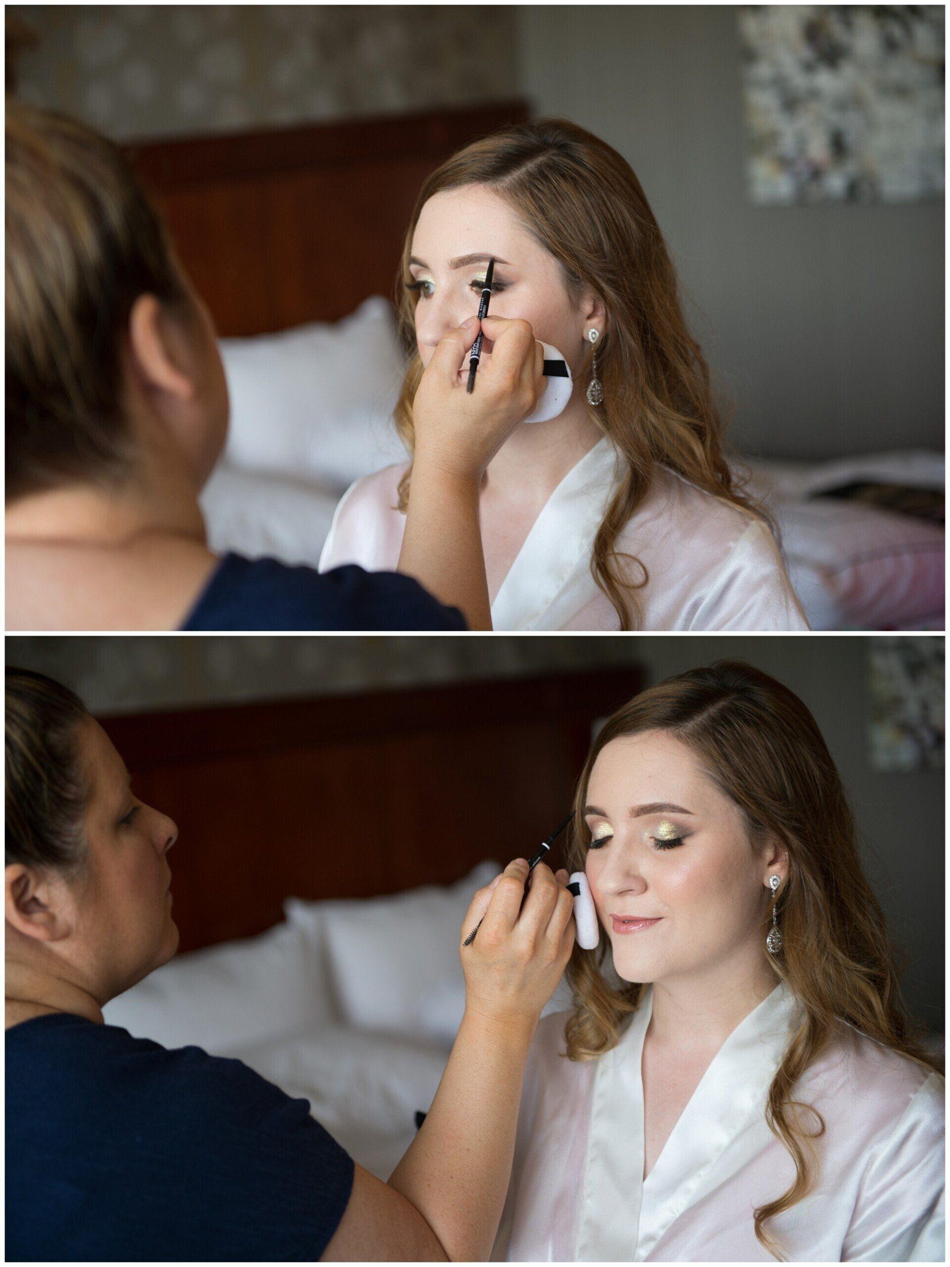Makeup artist applying eye makeup to a seated woman in a bedroom