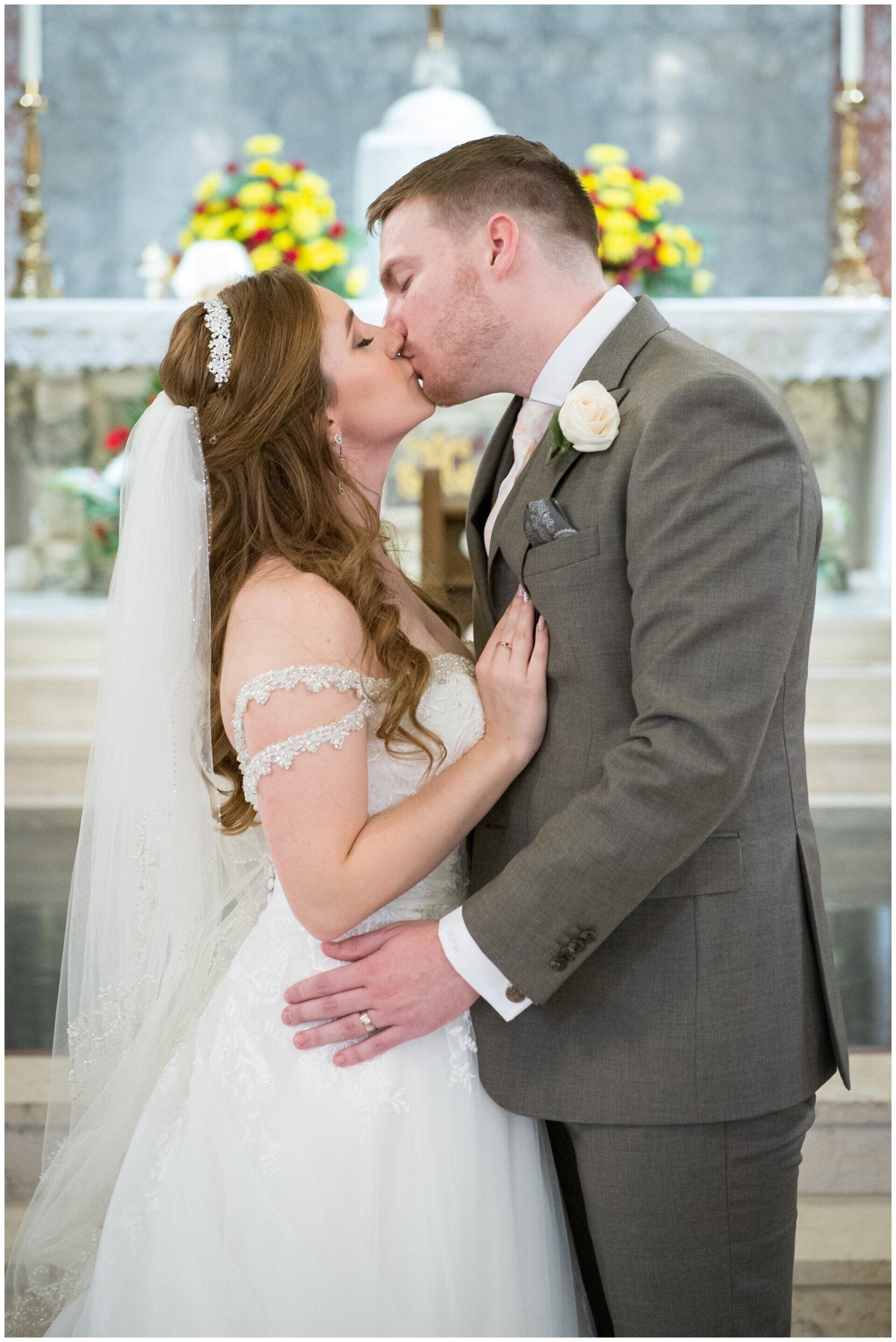Bride and groom kissing at the altar during a wedding ceremony