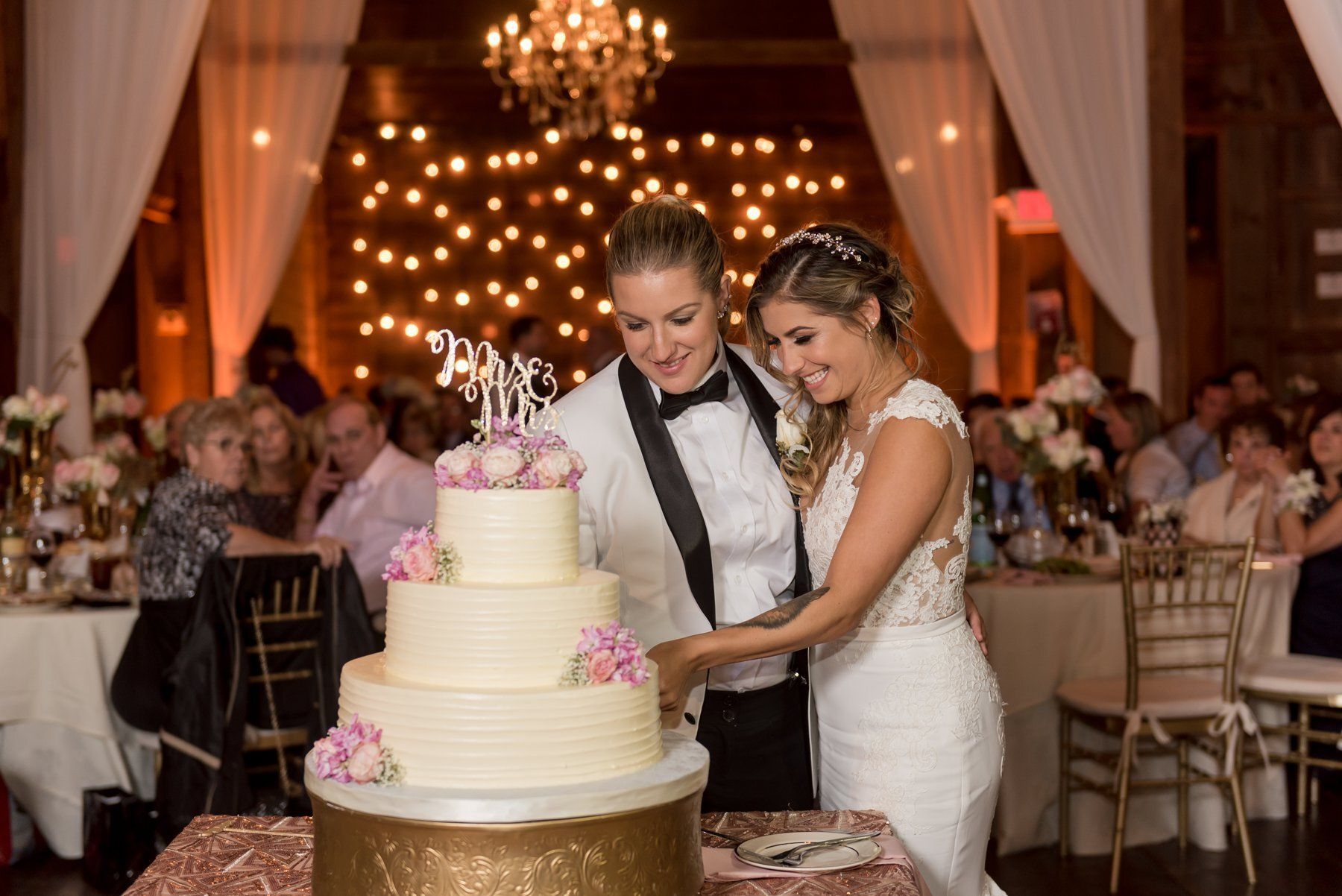 Bride and groom cutting a tiered wedding cake at their reception
