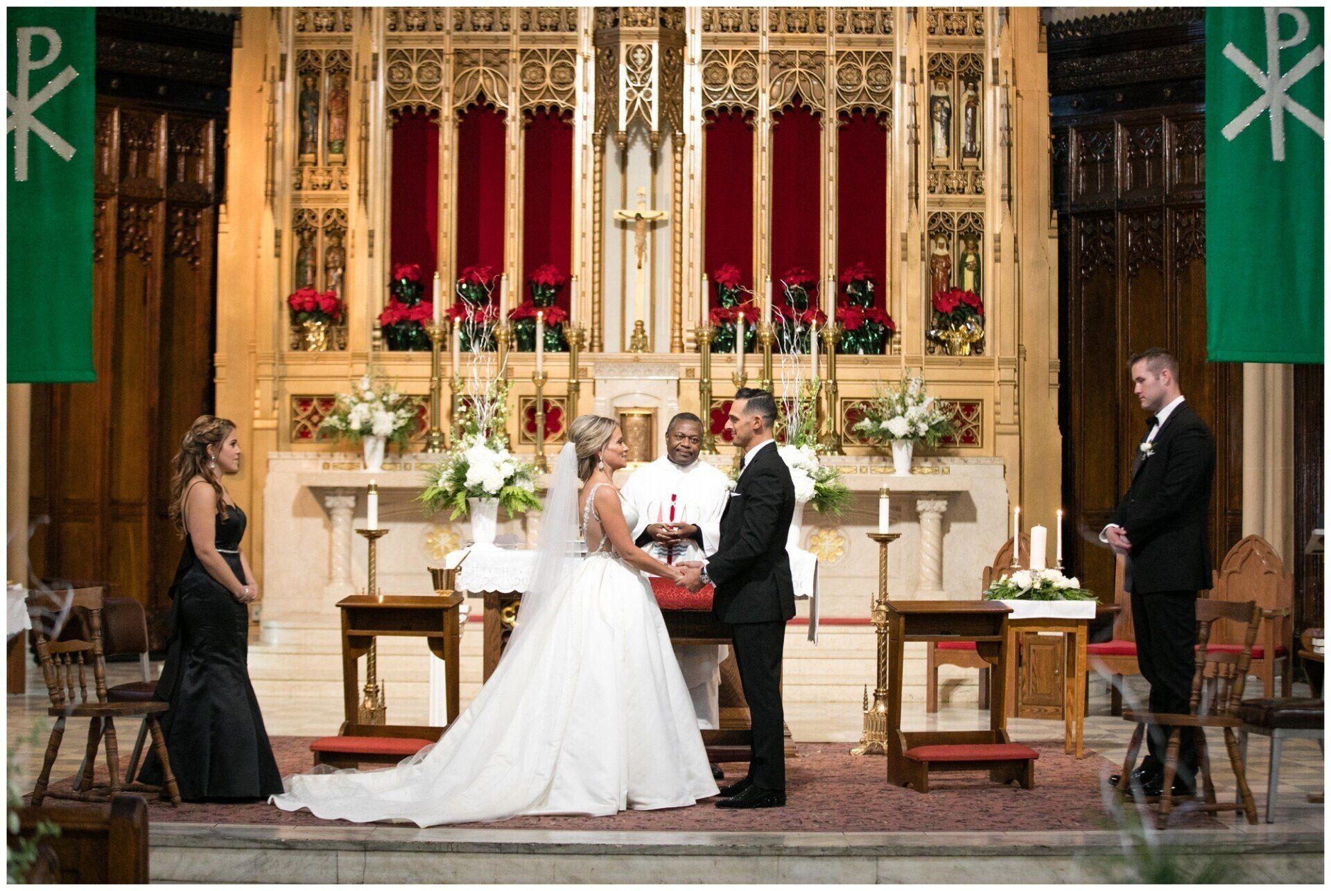 Bride and groom exchanging vows at the altar in a decorated church, with attendants nearby