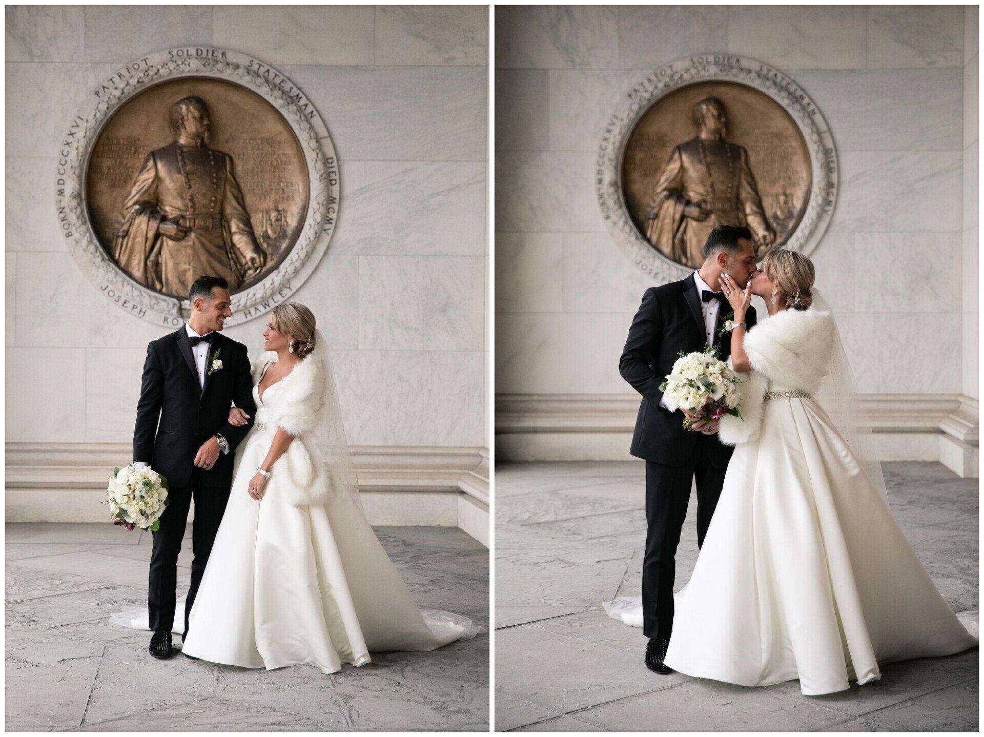 Bride and groom in white wedding attire posing in a marble hall with a classical statue medallion.