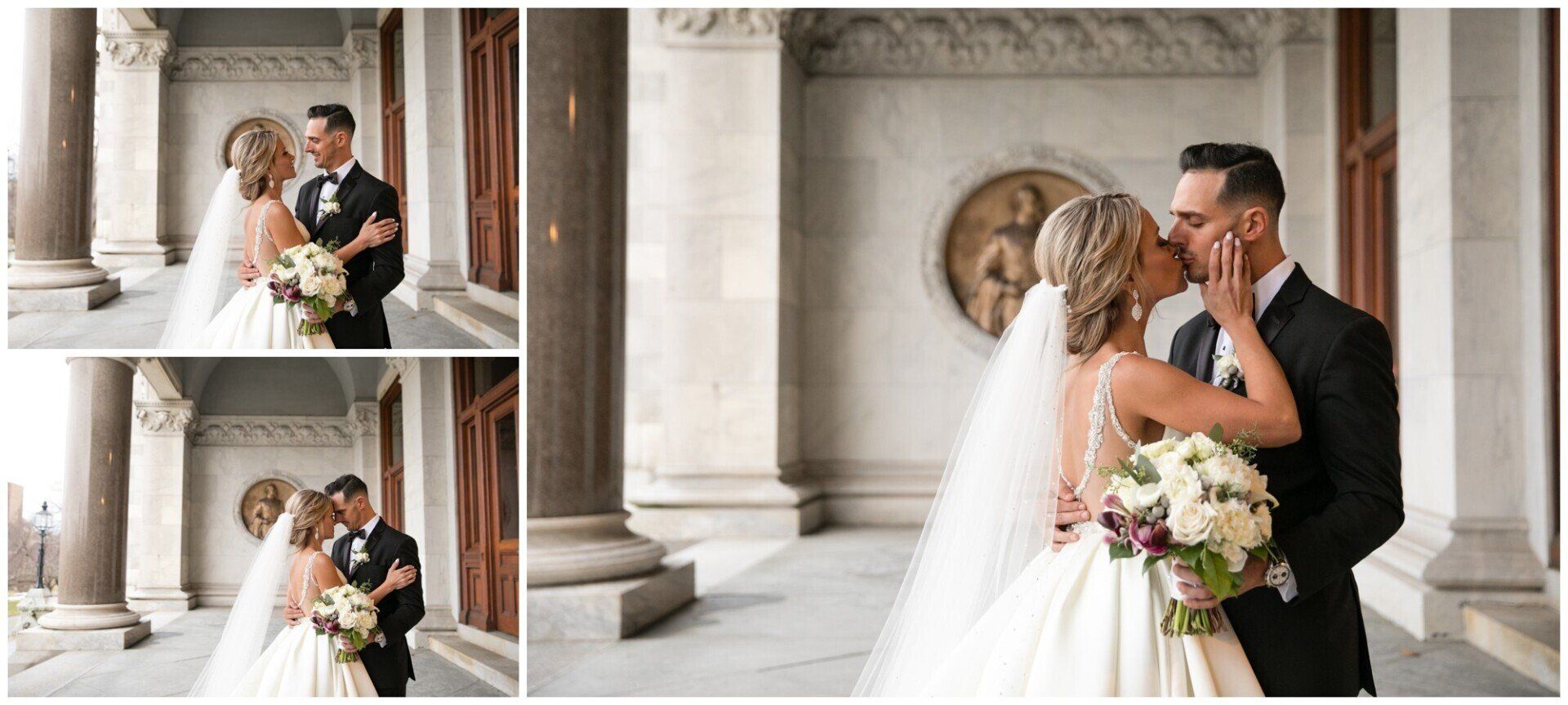 Bride and groom kiss in a marble hall beneath columns, with a bouquet in hand and wedding attire.