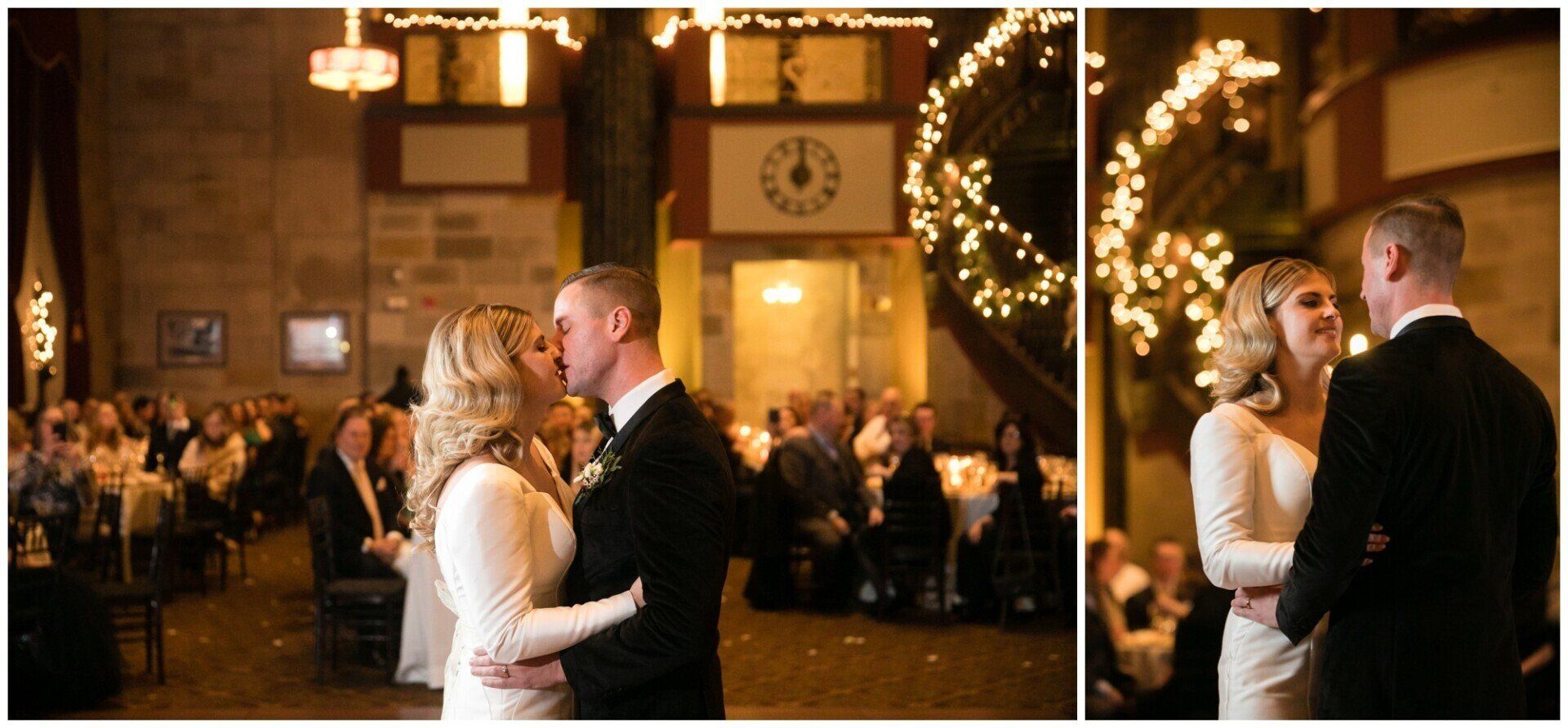 Couple slow dancing at a warmly lit wedding reception with guests and string lights in the background