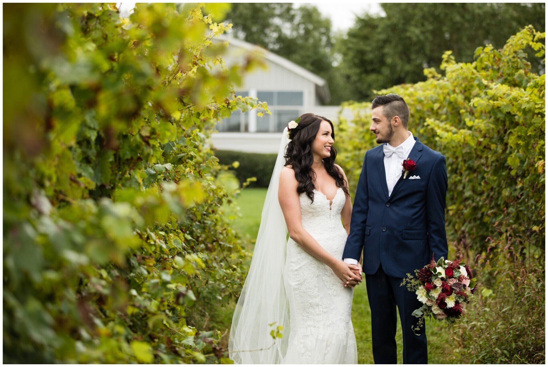 Bride and groom holding hands in a garden, smiling in wedding attire