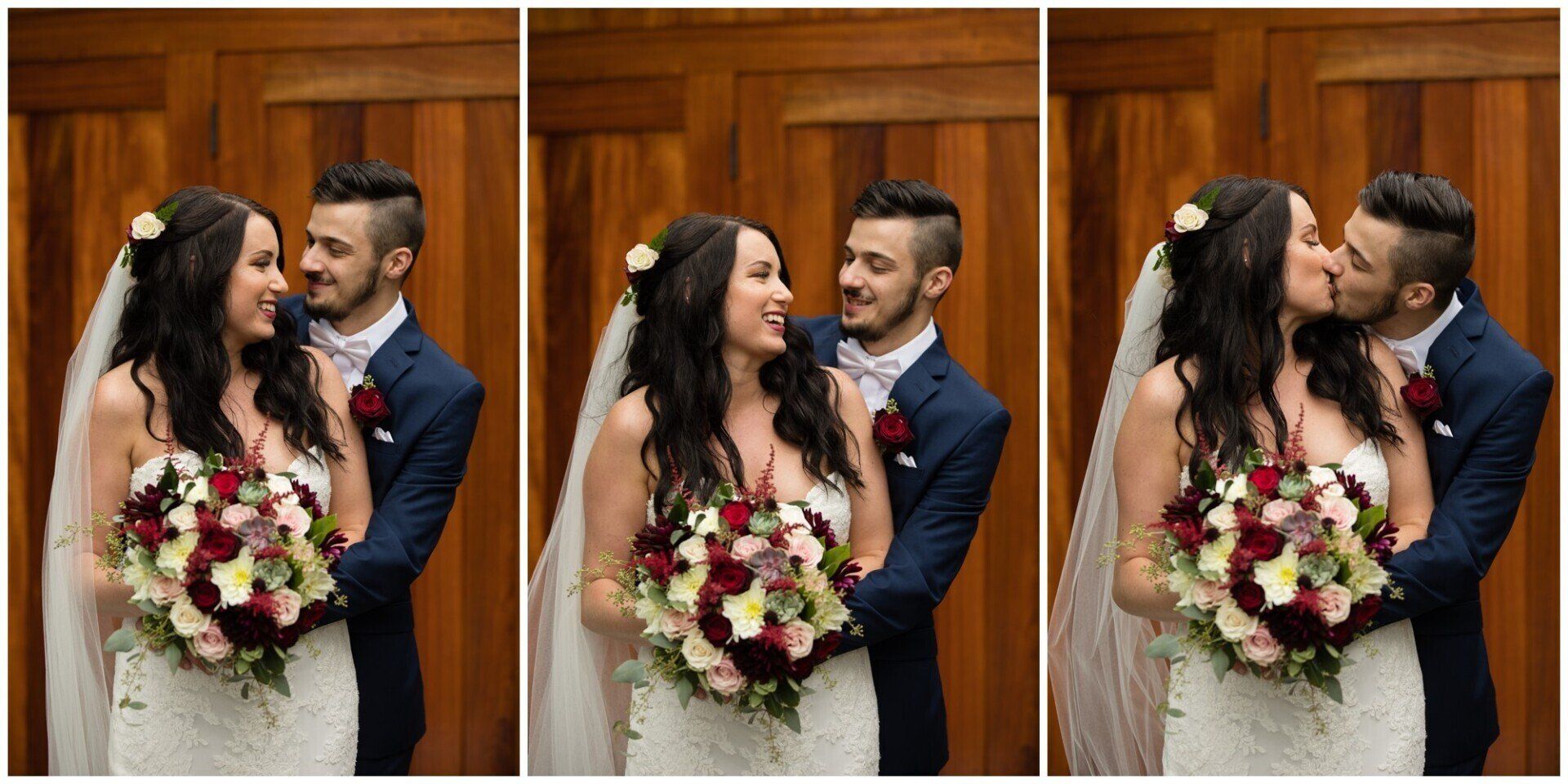 Bride and groom in wedding attire pose and kiss in front of wooden doors, holding a bouquet.