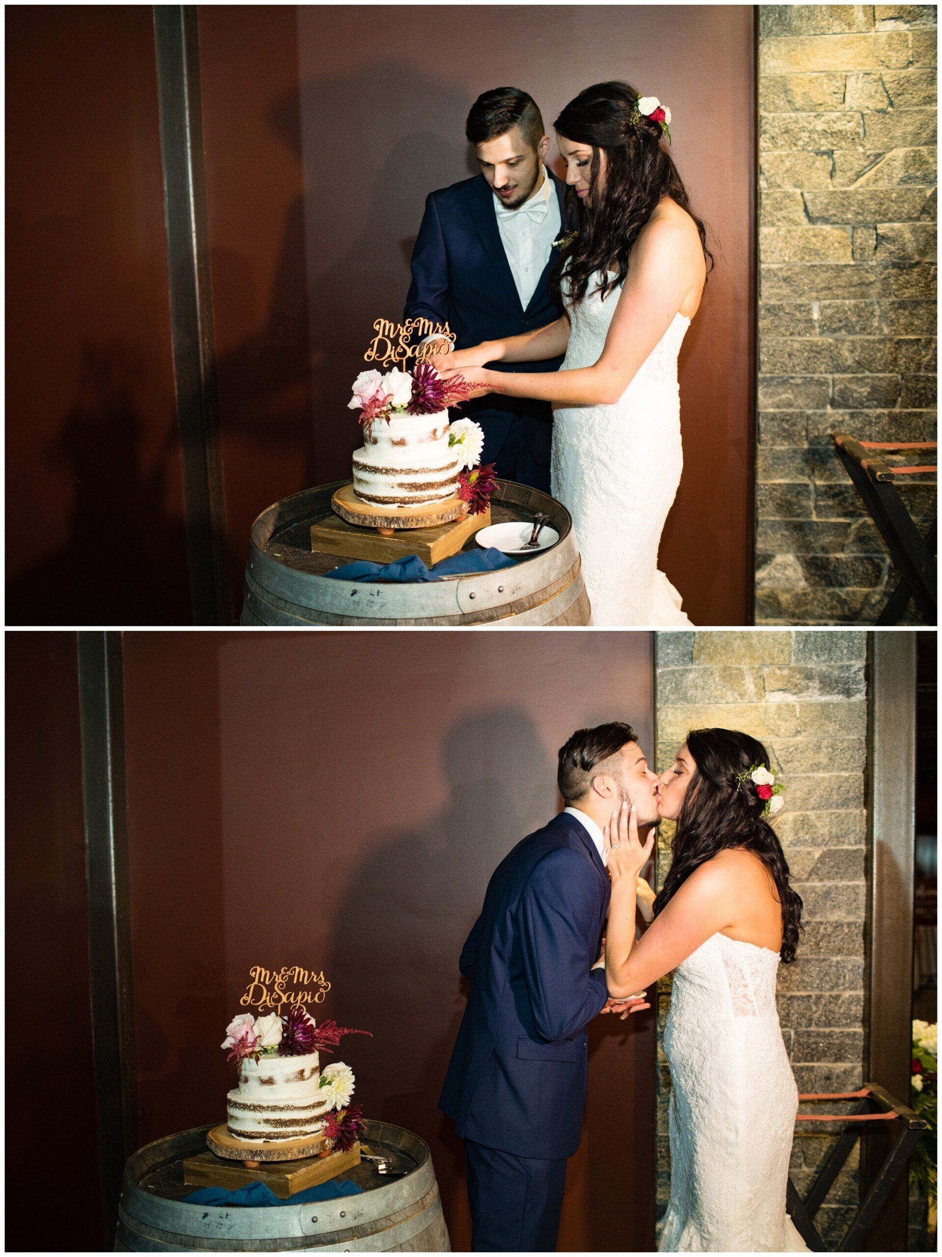 Bride and groom cut a wedding cake beside a rustic brick wall.