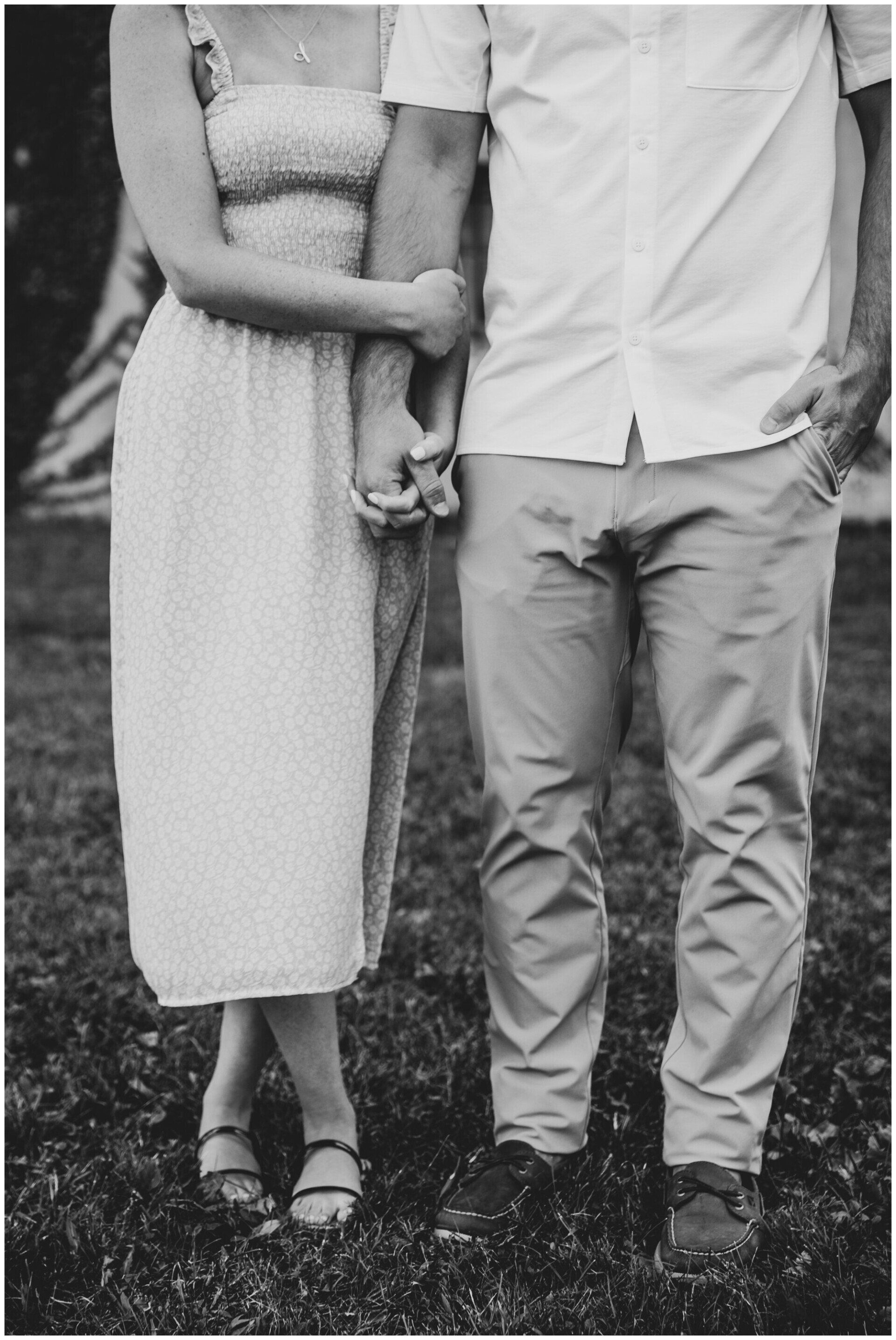 Couple standing together outdoors, holding hands, in a black-and-white photo