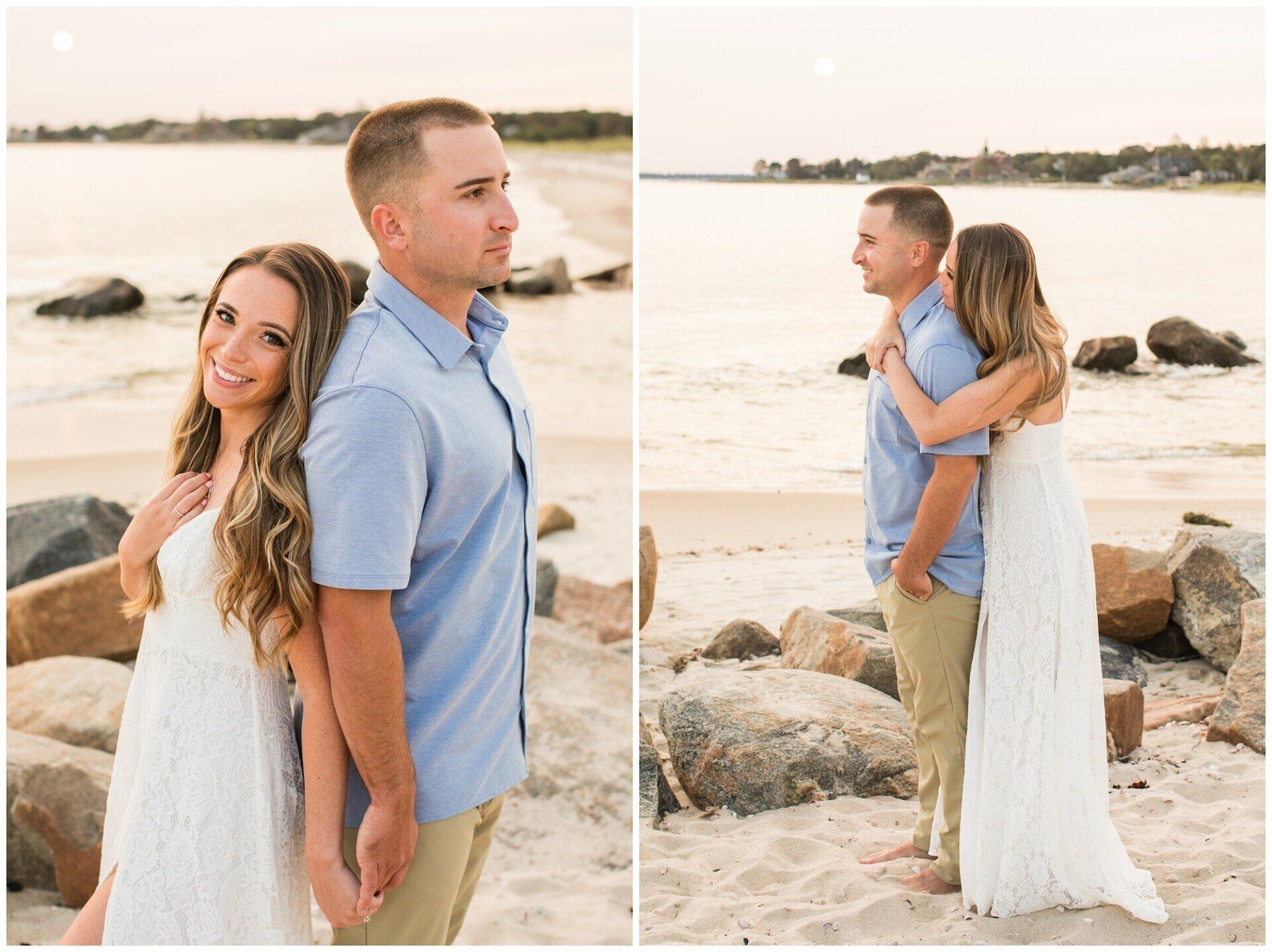 Couple standing on a beach at sunset, the woman smiling and leaning against the man near large rocks.