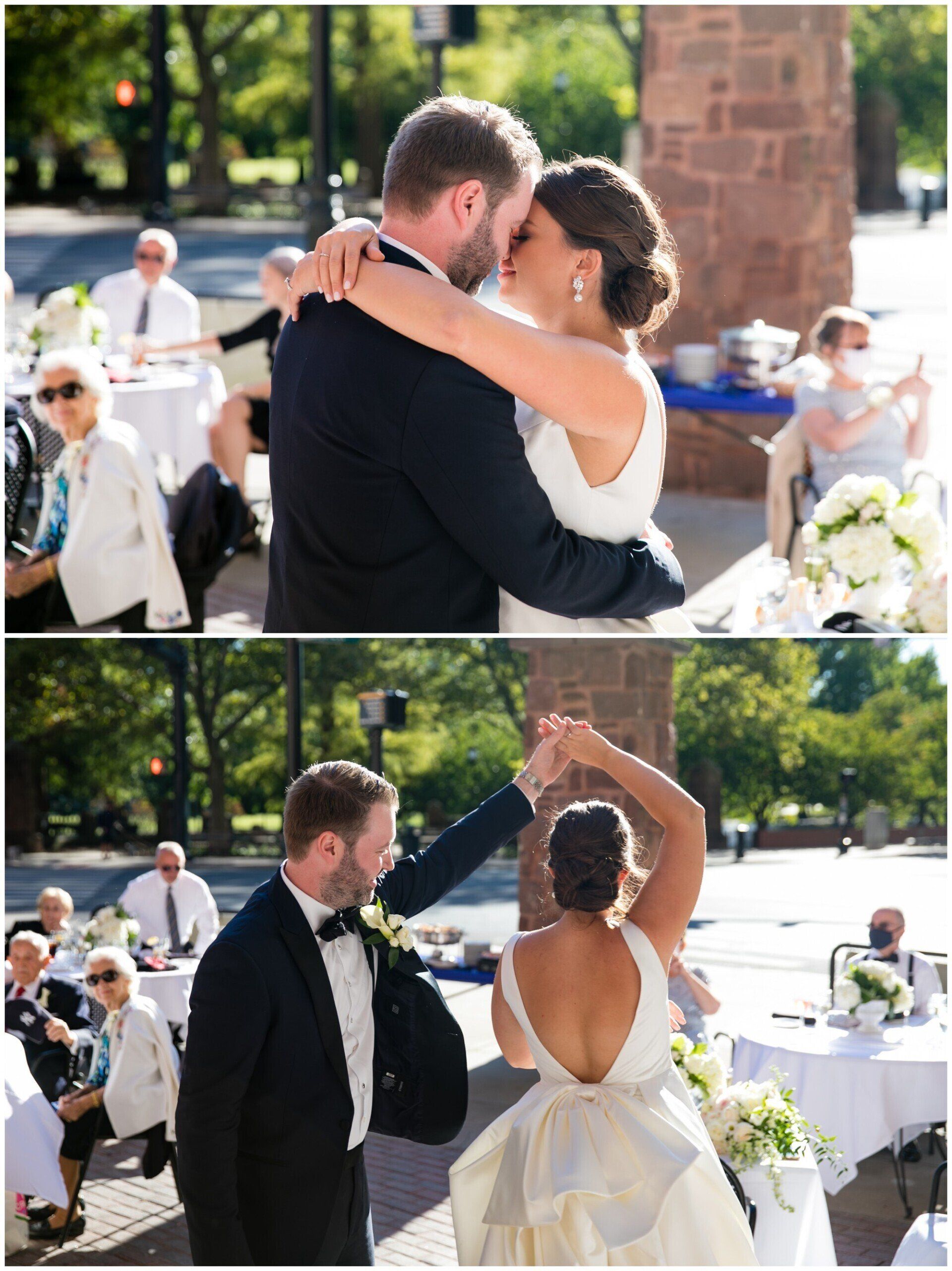 Wedding couple embracing outdoors; bride in white dress and groom in black suit share a dance and kiss.