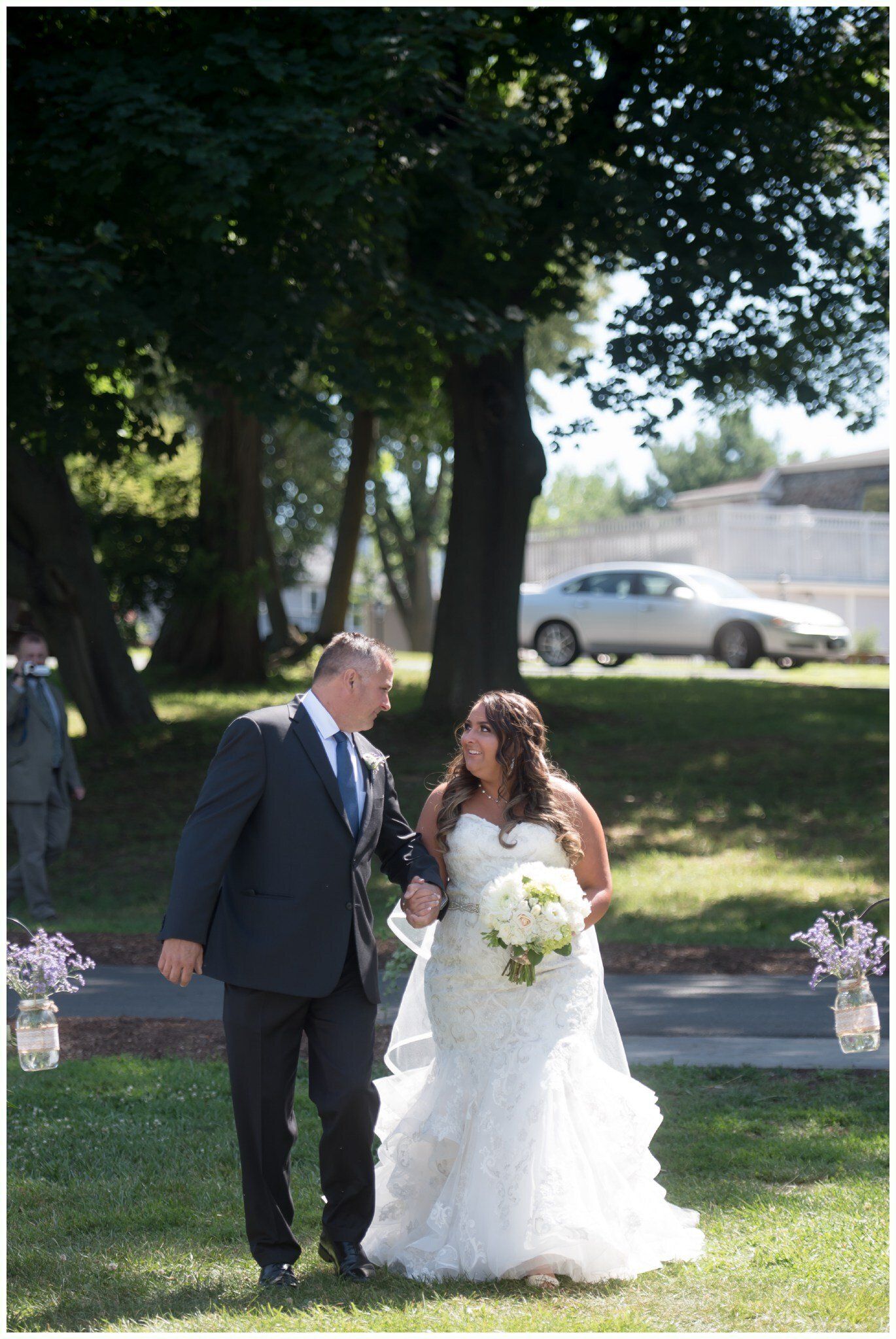 Bride and groom walking together outdoors in a garden during a wedding ceremony