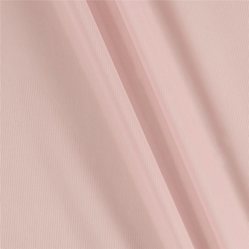 Close-up of pale pink fabric with soft diagonal folds and subtle texture