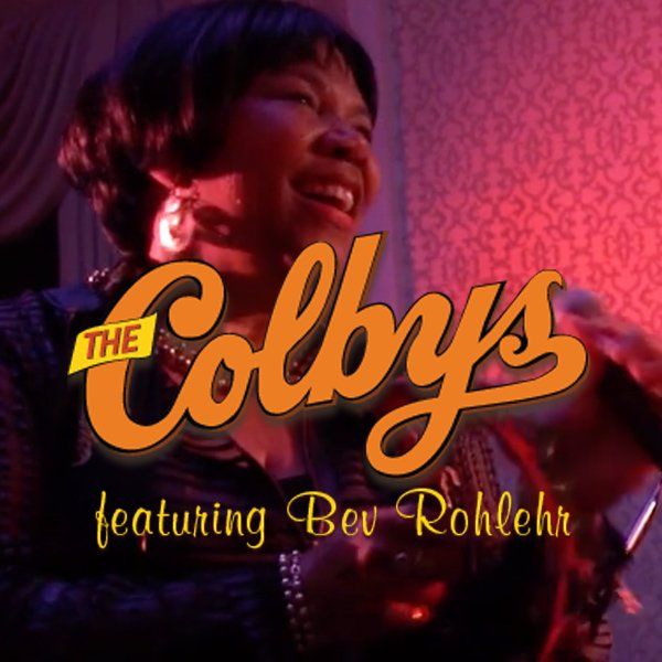 The Colbys featuring Bev Rohlchr in orange script over a pink-lit smiling singer