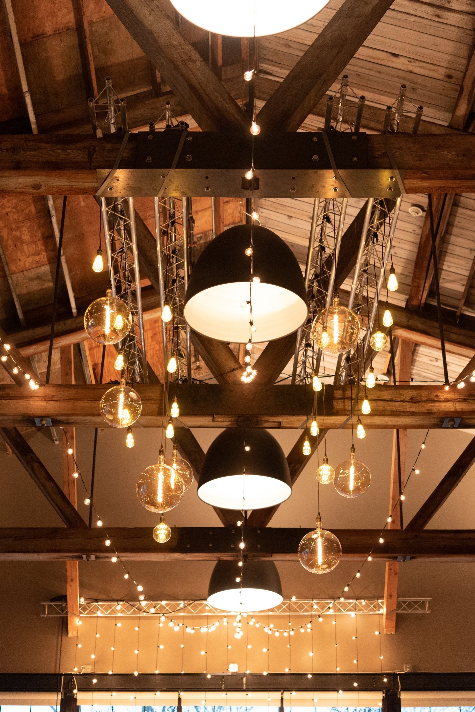 Warm-lit rustic ceiling with exposed beams and hanging pendant lights