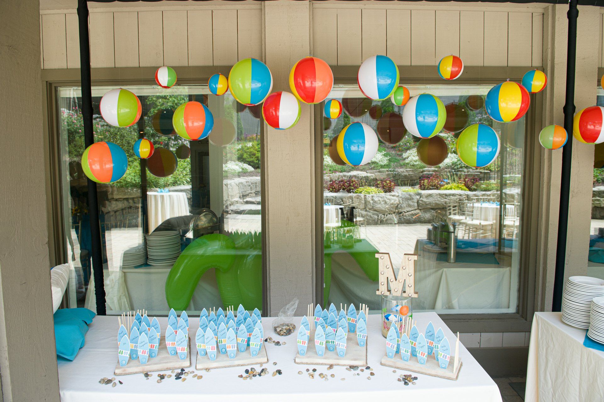 Colorful balloon decorations over a table with gifts and treats at an outdoor party setup