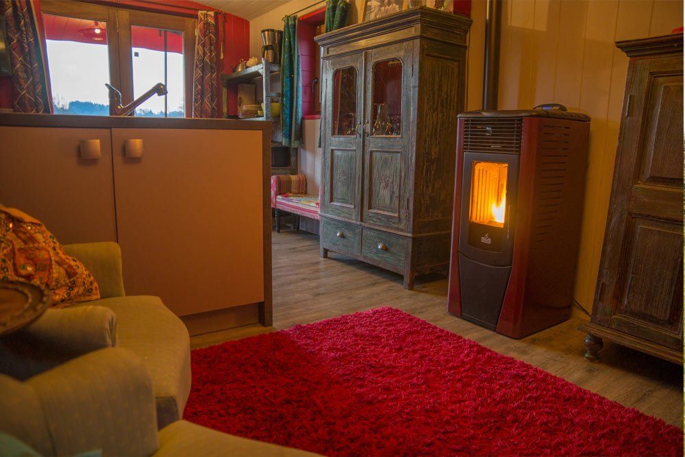 huiskamer met houtkachel in de roulotte