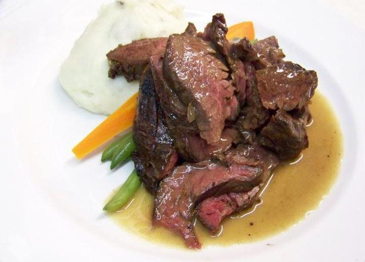 A white plate topped with steak mashed potatoes and carrots