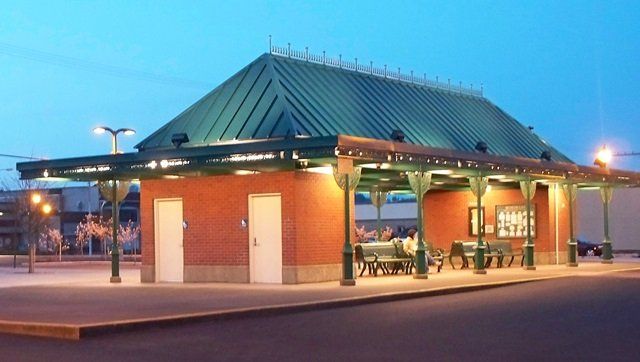A brick building with a green roof is lit up at night - Aberdeen Transit Center