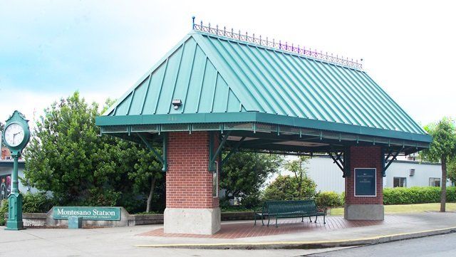A green roofed building with a clock on top of it - Montesano Transit Center