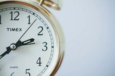 Close-up of a gold Timex alarm clock showing the time as 2:08.