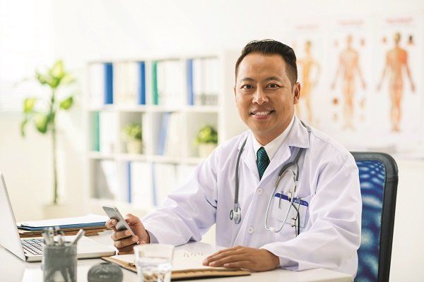 A smiling doctor with a cell phone A smiling doctor with a cell phone