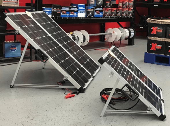 Two solar panels are sitting next to each other in a garage