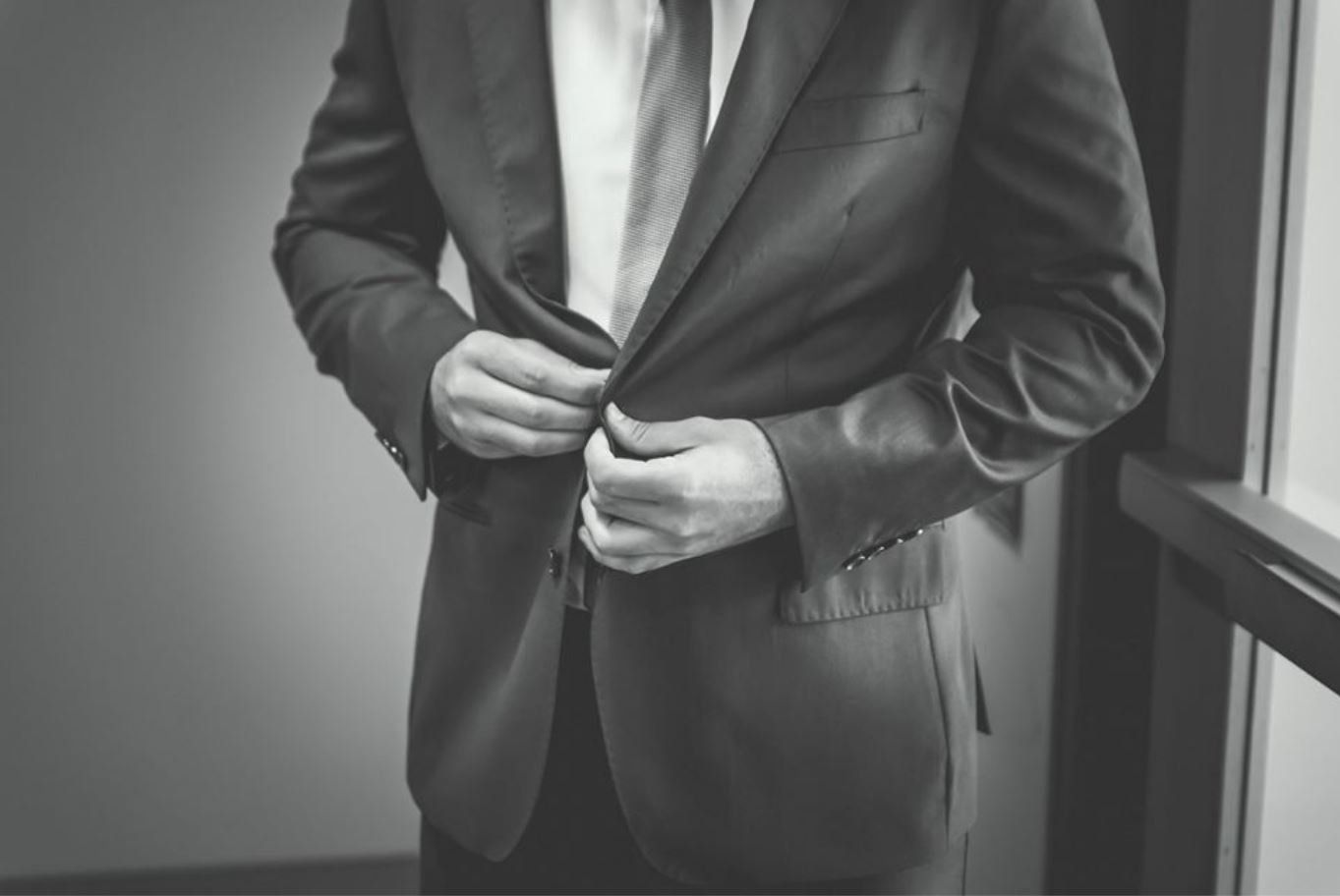 gentleman buttoning up a suit
