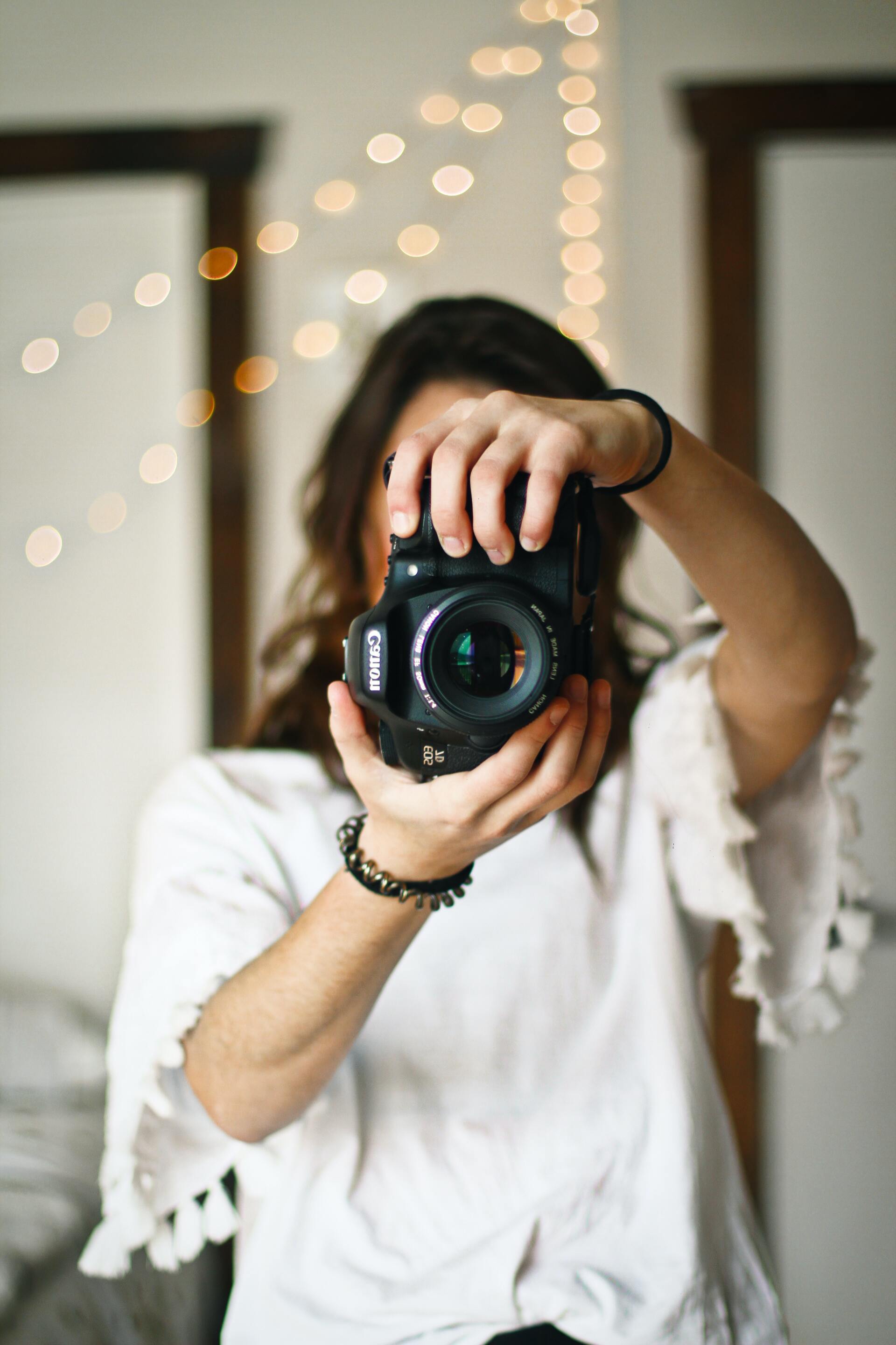 Vrouw met camera, wazige achtergrond met lichtslingers.