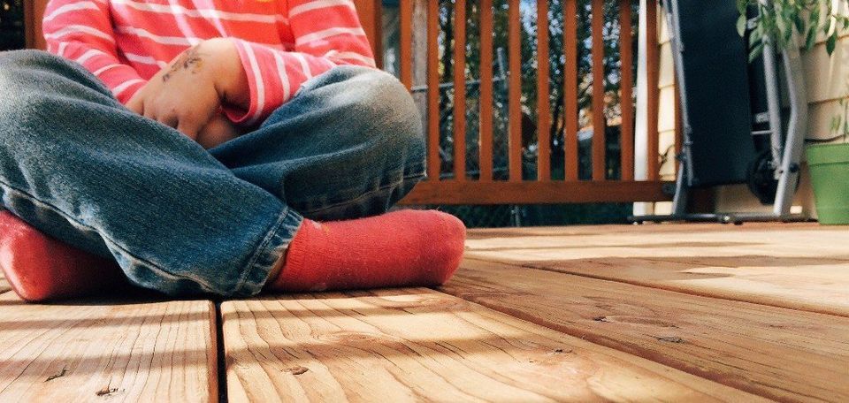 A Person Sitting On Wooden Deck — Muncie, IN — American Pest Control A Person Sitting On Wooden Deck — Muncie, IN — American Pest Control