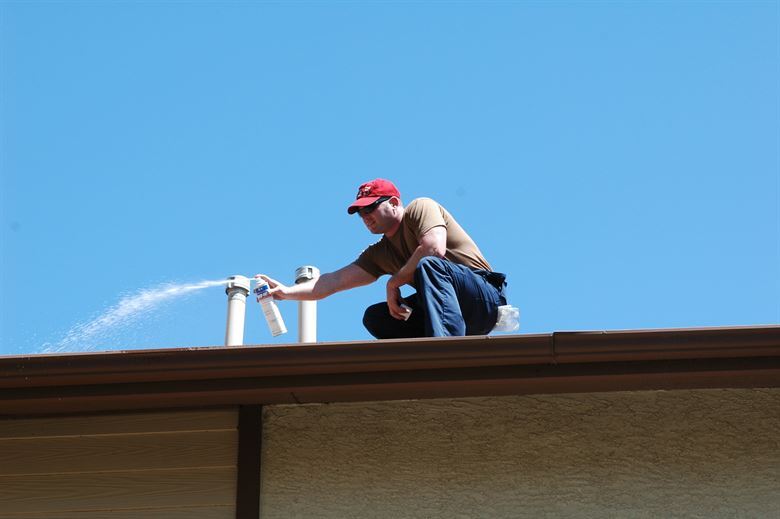 Man Cleaning House Roof — Muncie, IN — American Pest Control Man Cleaning House Roof — Muncie, IN — American Pest Control