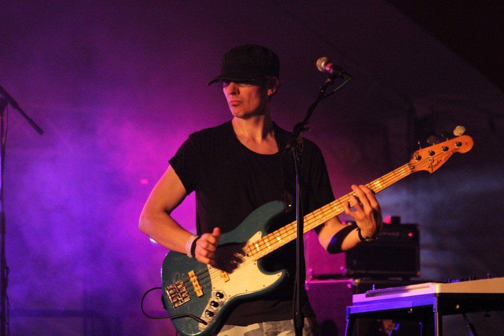 A man is playing a guitar and singing into a microphone