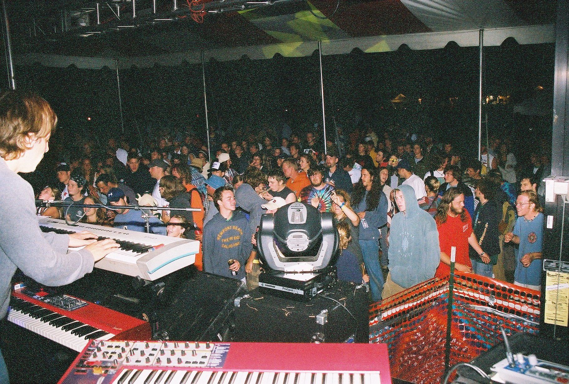 A man is playing a keyboard in front of a crowd.