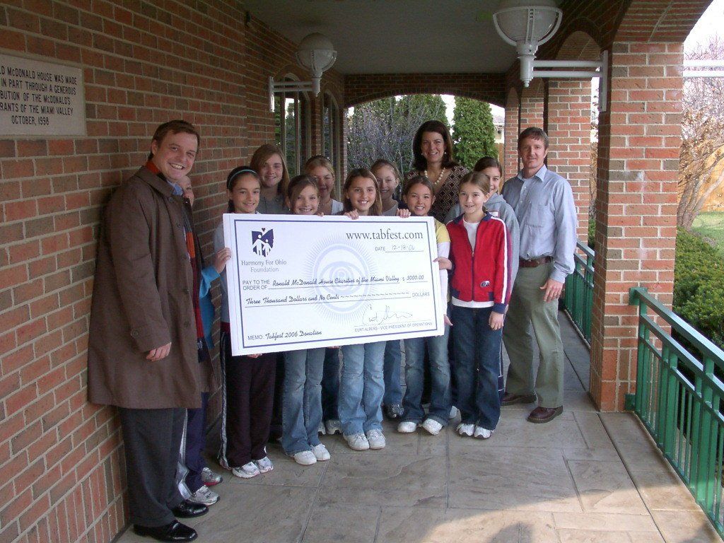 A group of people holding a large check 