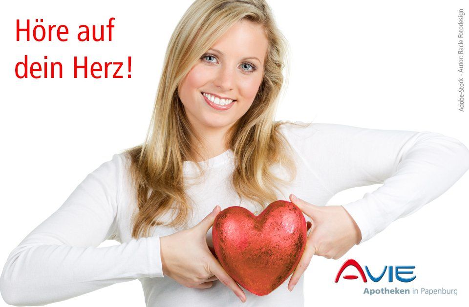 Eine Frau hält ein rotes Herz in ihren Händen.