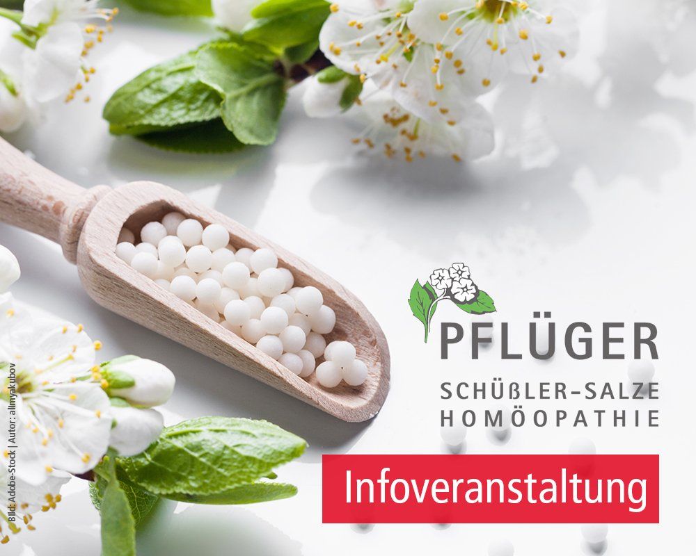 Ein Holzlöffel gefüllt mit weißen Pillen neben weißen Blumen.