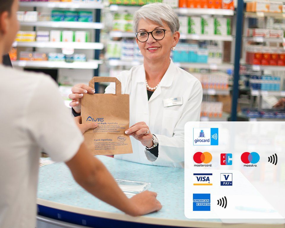 Eine Frau gibt einem Mann in einer Apotheke eine Tüte.