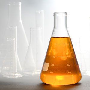 A beaker filled with yellow liquid is sitting on a table.