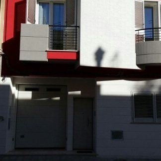 Casa con persiane bianche e porta basculante bianca
