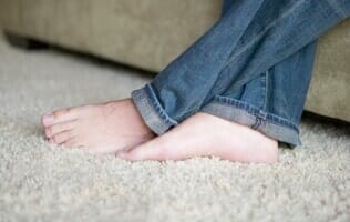 Person Sitting On Sofa — Carpets in Mahomet, IL Person Sitting On Sofa — Carpets in Mahomet, IL