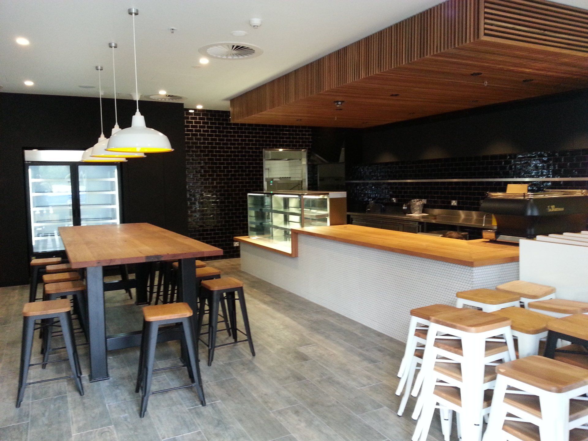 A restaurant with a table and stools and a counter