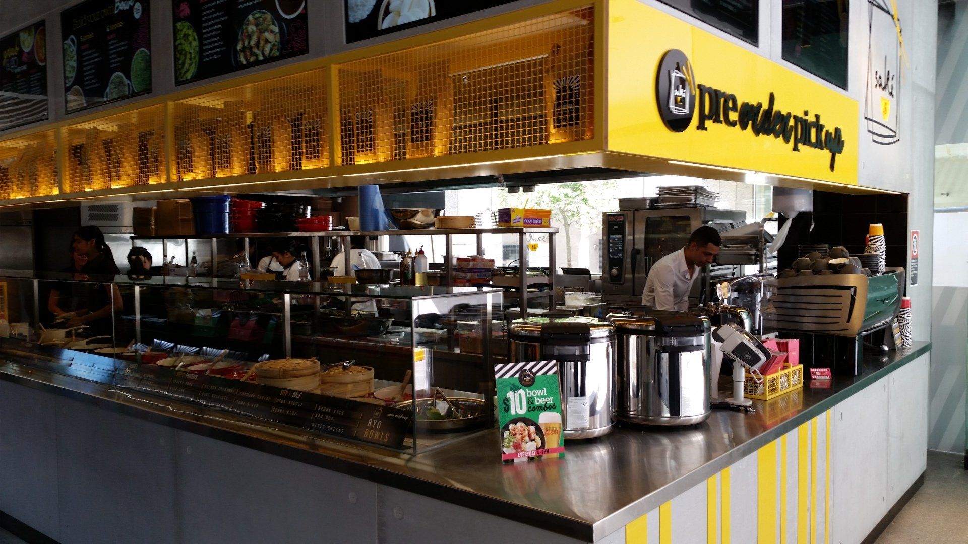 A man is standing behind a counter in a restaurant.