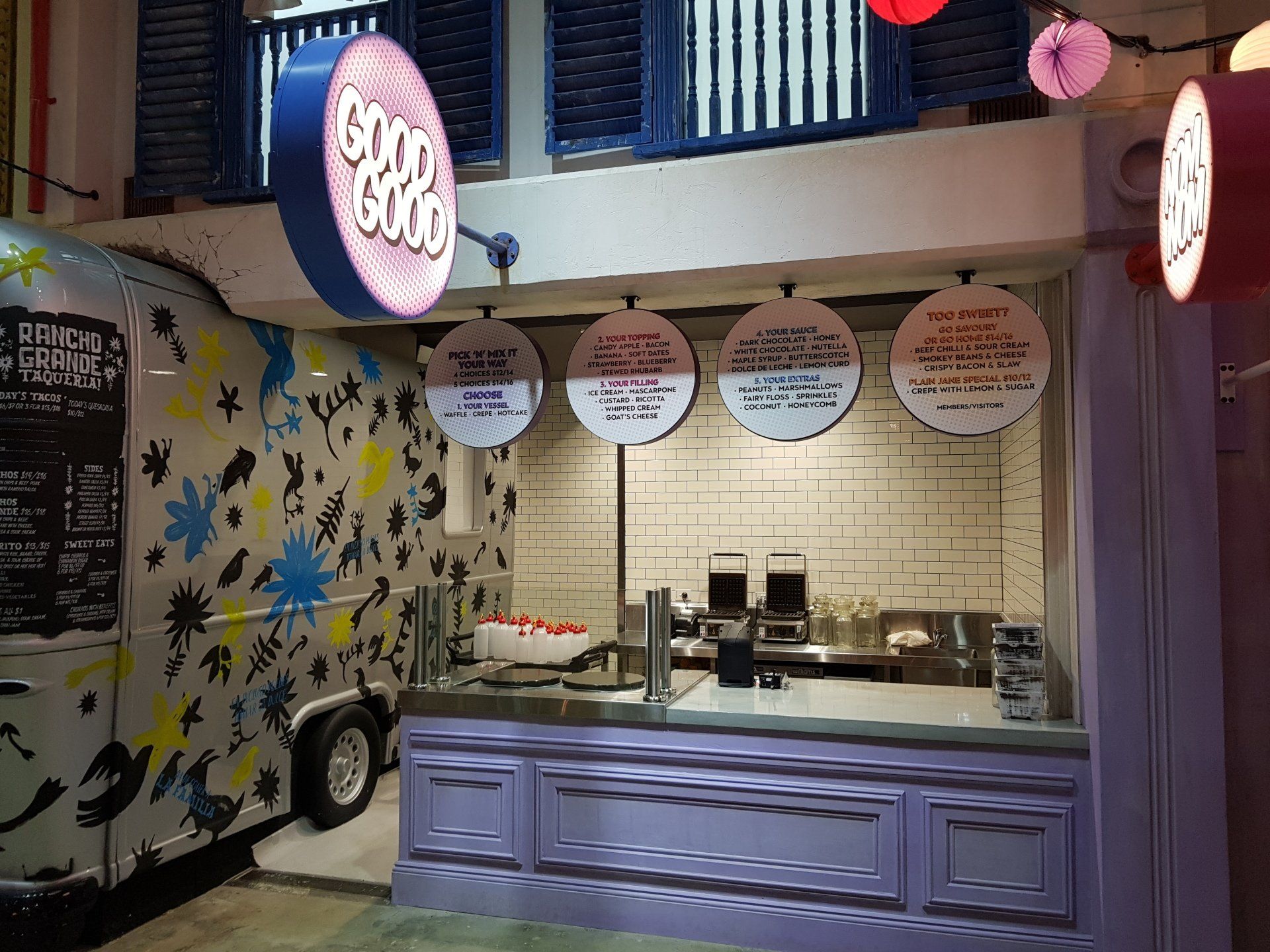 A food truck is parked in front of a restaurant.